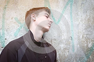 Young man leaning against a wall