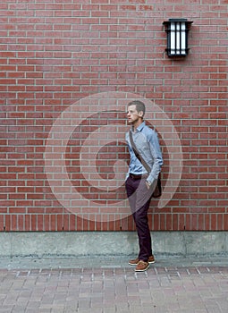 Young Man Leaning On A Brick Wall