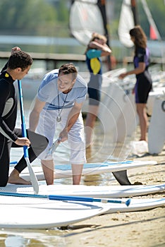 young man learning paddle surf