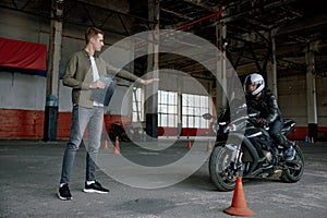 Young man learning to ride bike at private school maneuvering between cones