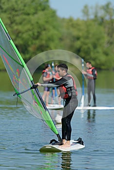 Young man learning windsurfing