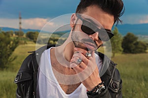 Young man in leather jacket and sunglasses thinking