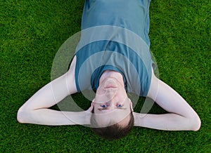 The young man lies on a grass