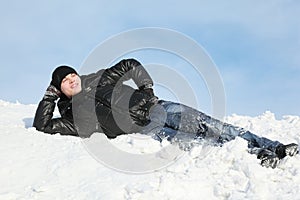 Young man lies on snow support palm