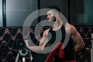 Young Man Lifting Dumbbell In Gym