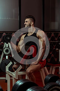 Young Man Lifting Dumbbell In Gym