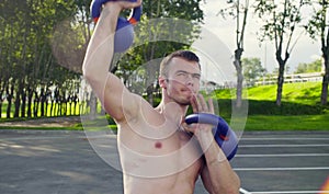 A young man is lifting dumbbells