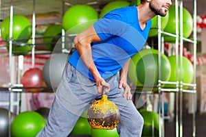 Young man lifting dumbbells at crossfit gym