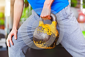 Young man lifting dumbbells at crossfit gym