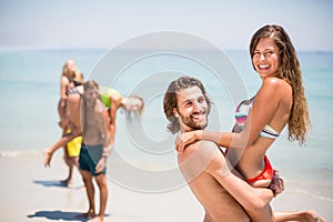 Young man lifting woman at beach