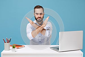 Young man in light shirt sit work at desk with pc laptop isolated on pastel blue background. Achievement business career