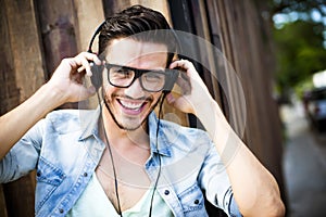 Young man listening music on the street - hipster style