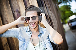 Young man listening music on the street - hipster style