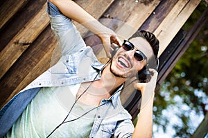 Young man listening music on the street - hipster style