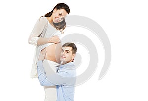 Young Man Listening To His Wife`s Pregnant Belly On A White Background, Woman Pregnancy photo