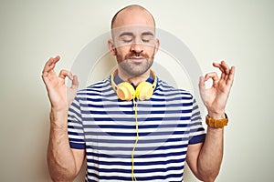 Young man listening to music wearing yellow headphones over isolated background relax and smiling with eyes closed doing