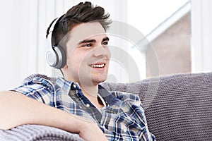 Young Man Listening To Music On Wireless Headphones