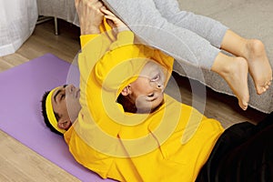 Young man with little boy doing fitness exercises at home. Father and son having fun during sport. Dad and his child