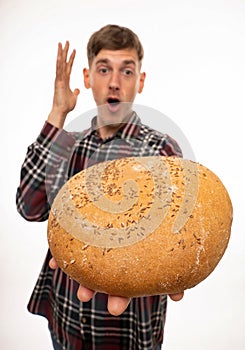 Young man with loaf of bread on white