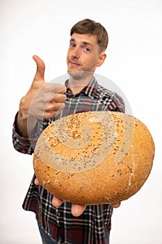 Young man with loaf of bread on white