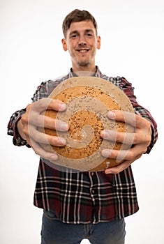 Young man with loaf of bread on white