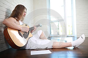 Young man with long hair with a guitar