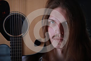 Young man with long hair with a guitar