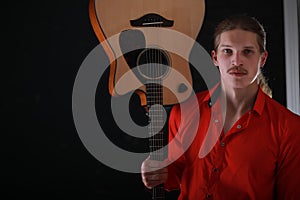 Young man with long hair with a guitar