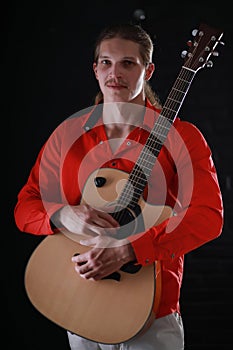 Young man with long hair with a guitar