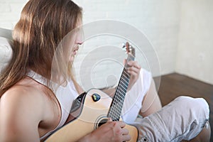 Young man with long hair with a guitar