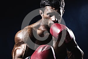 Young man looking aggressive with boxing gloves. Caucasian male