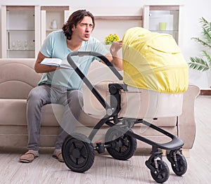 Young man looking after baby in pram