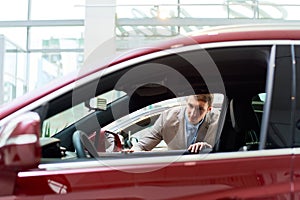 Young Man Looking at Cars in Showroom