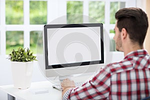 Young man looking at computer screen photo