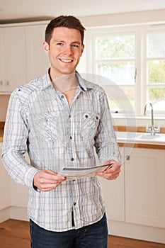 Young Man Looking At Details For New Home