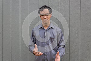 Young man looking down conflicted, bi-racial millennial male, natural black hair in short dreads