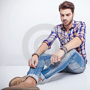 Young man looking down while sitting on the floor