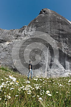 Young man looking at huge rock in Castle Hill. Canterbury region  New Zealand