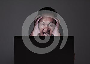 Young Man Looking at Laptop, Angry Gesture
