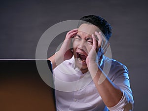 Young Man Looking at Laptop, Angry Gesture