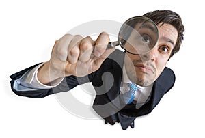 Young man is looking through magnifying glass. Isolated on white background. View from top