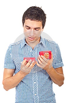 Young man looking into a open small gift