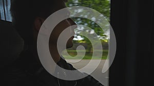 Young man looking out the window during bus ride