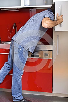 Young man looking in refrigerator