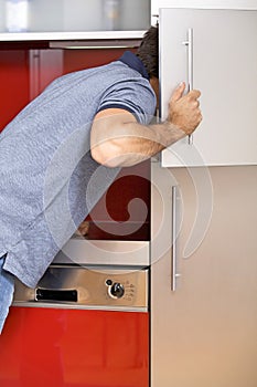 Young man looking in refrigerator