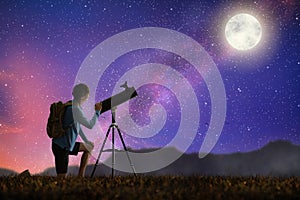 Young man looking at stars through telescope