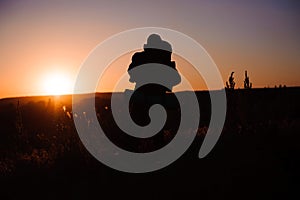 Young man is looking at sunset. Traveller with backpack