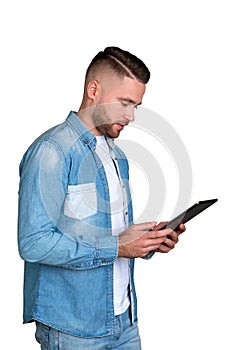 Young man looking at tablet in hands, isolated over white background