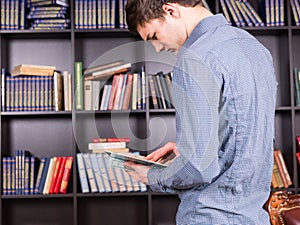 Young man looking up information in a book