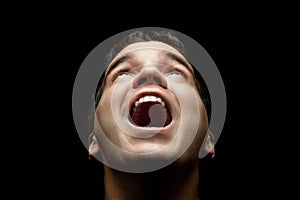 Young man looking up isolated on black